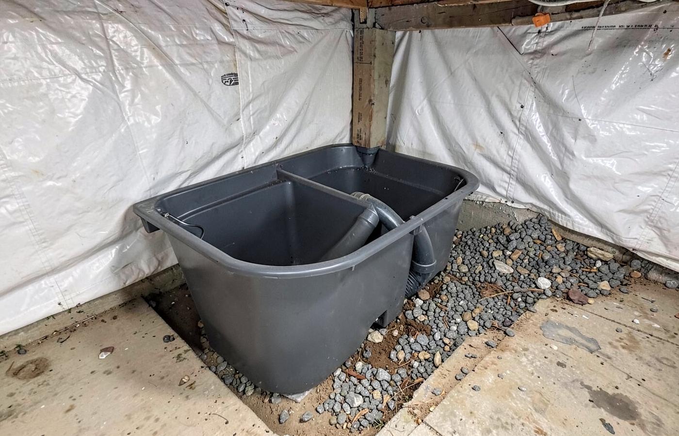 Sealed sump basin and drainage stone installed in a coastal crawl space